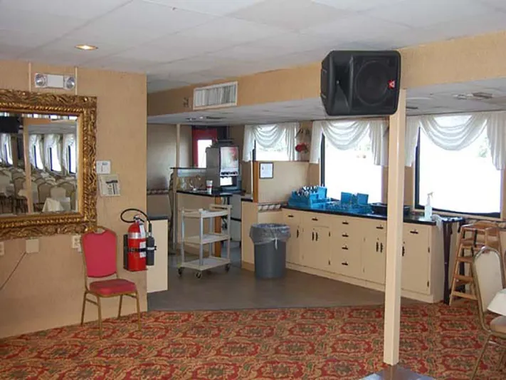 Capt. Jp III Yacht Photos Pics Interior of 1985 Custom Serodino Dinner Boat with ornate mirror, red chair, and patterned carpet.