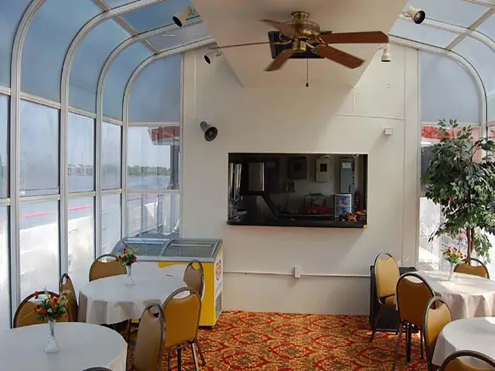 Capt. Jp III Yacht Photos Pics Interior of 1985 Custom Serodino Dinner Boat with tables, chairs, and ceiling fan.