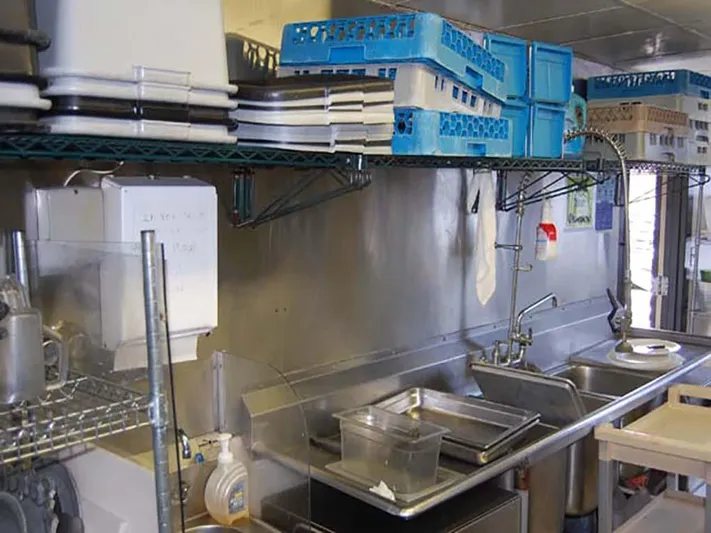 Capt. Jp III Yacht Photos Pics Kitchen area on 1985 Custom Serodino Dinner Boat with shelves, dishes, and sink.
