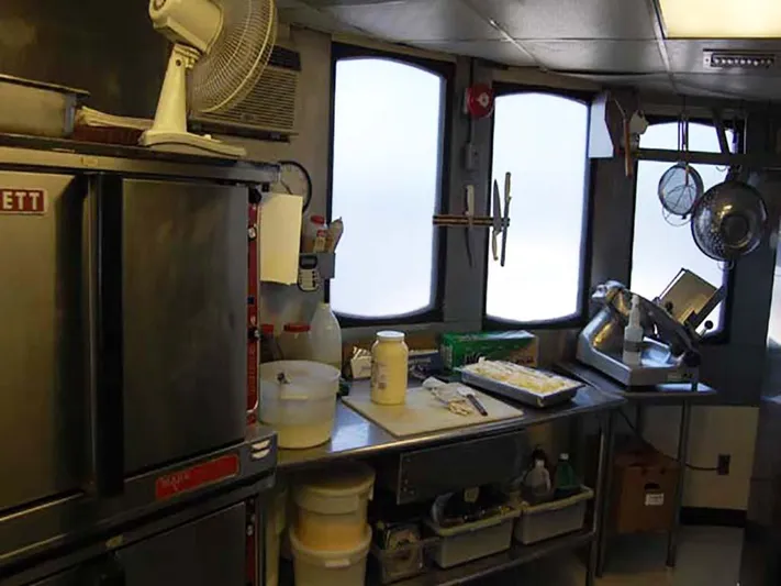 Capt. Jp III Yacht Photos Pics Kitchen interior of 1985 Custom Serodino Dinner Boat with cooking equipment and supplies.