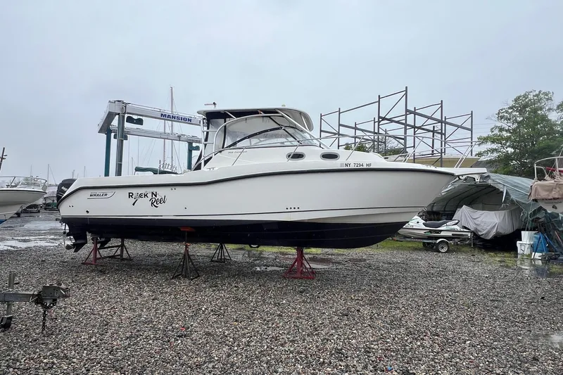 Rock N Reel Yacht Photos Pics 2005 Boston Whaler 305 Conquest boat on stands in a marina setting.