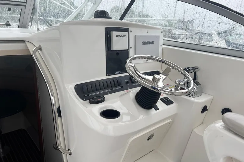 Rock N Reel Yacht Photos Pics 2005 Boston Whaler 305 Conquest helm with steering wheel and navigation controls.