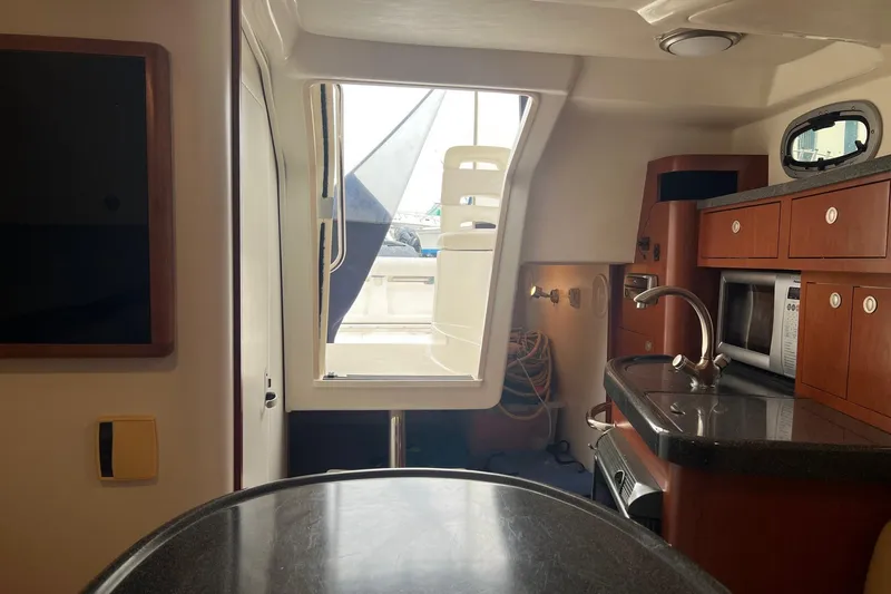 Rock N Reel Yacht Photos Pics Interior of 2005 Boston Whaler 305 Conquest boat, featuring kitchenette and seating area.