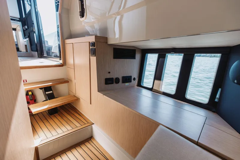  Yacht Photos Pics 2026 XO Boats EXPLR 44 interior with wooden steps, modern cabinetry, and large windows overlooking water.