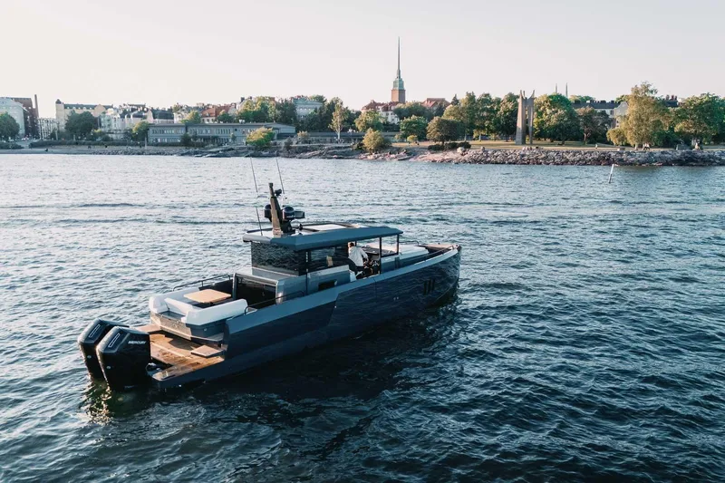  Yacht Photos Pics 2026 XO Boats EXPLR 44 cruising near a scenic shoreline with cityscape backdrop.