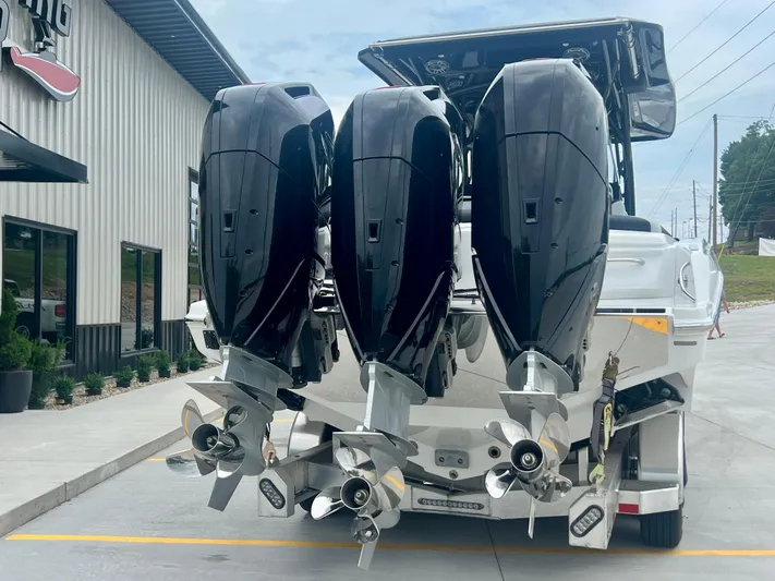  Yacht Photos Pics 2025 Nor-Tech 340 Sport Center Console with triple outboard engines, parked outside a building.