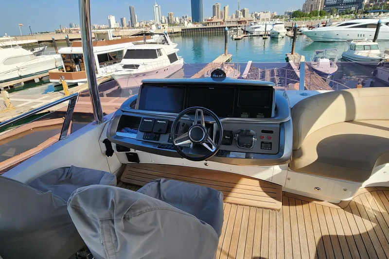  Yacht Photos Pics Luxurious 2019 Princess F62 yacht helm with modern controls, docked in a scenic marina.