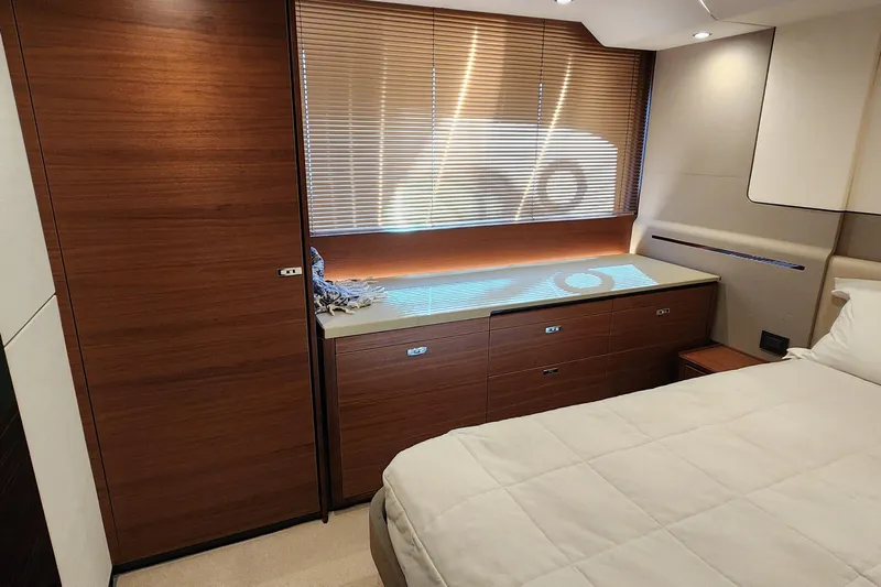  Yacht Photos Pics Luxurious cabin interior of 2019 Princess F62 yacht with wooden accents and cozy bedding.