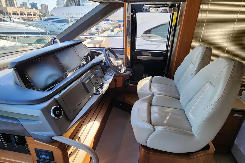  Yacht Photos Pics Interior cockpit of 2019 Princess F62 yacht with modern controls and leather seating.