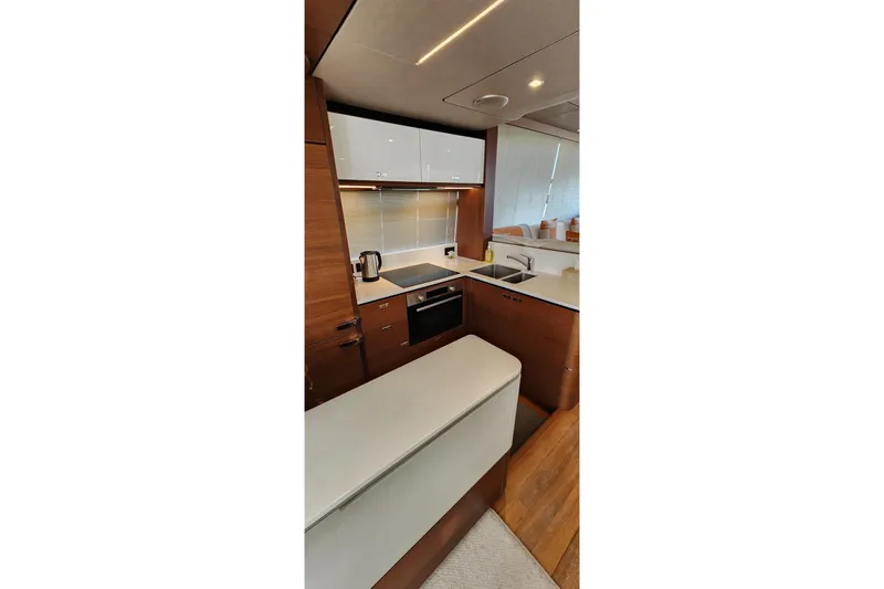 Yacht Photos Pics Modern kitchen interior on 2019 Princess F62 yacht, featuring sleek cabinetry and appliances.