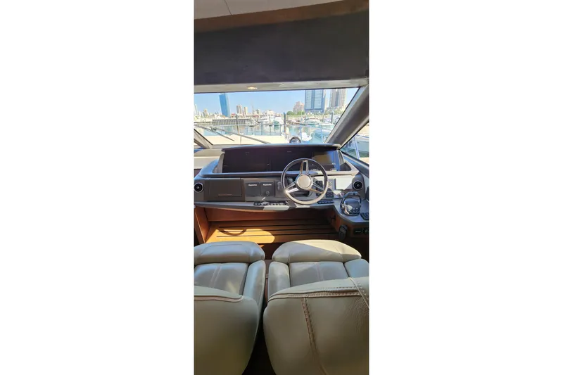  Yacht Photos Pics Interior view of 2019 Princess F62 yacht cockpit with leather seats and steering wheel.