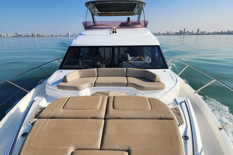  Yacht Photos Pics Luxurious 2019 Princess F62 yacht cruising on calm waters with city skyline backdrop.