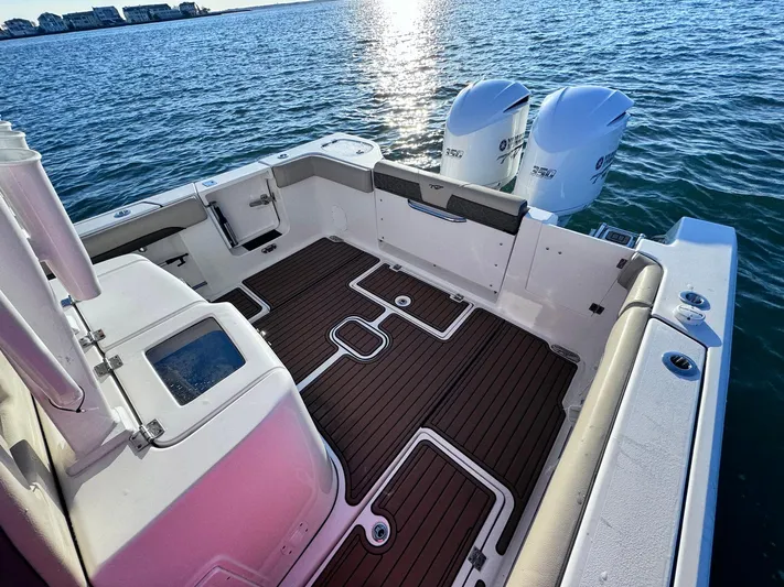 Suadha Yacht Photos Pics 2021 Tidewater 320 CC Adventure boat deck with twin engines on calm water.