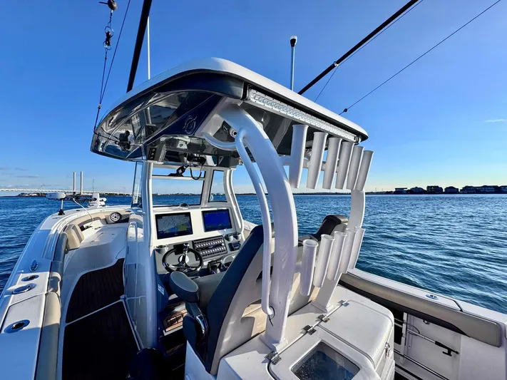Suadha Yacht Photos Pics 2021 Tidewater 320 CC Adventure boat on water, featuring modern helm and fishing rod holders.