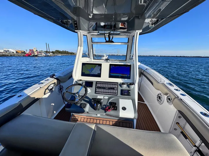 Suadha Yacht Photos Pics 2021 Tidewater 320 CC Adventure boat interior with navigation screens on open water.