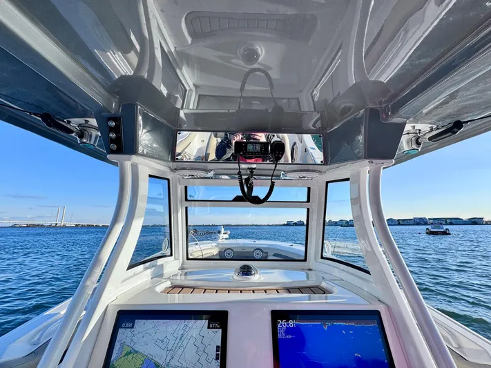 Suadha Yacht Photos Pics 2021 Tidewater 320 CC Adventure boat cockpit with navigation screens, on a sunny day at sea.