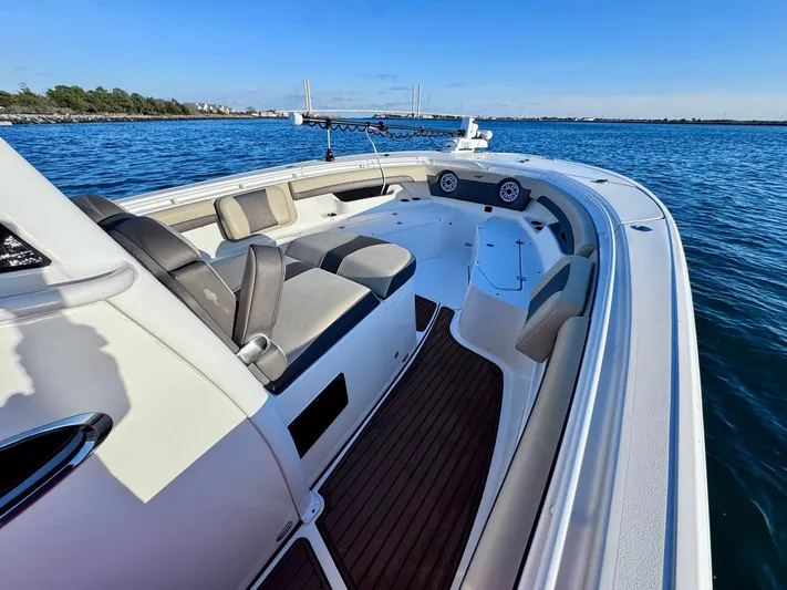 Suadha Yacht Photos Pics 2021 Tidewater 320 CC Adventure boat on calm water, featuring spacious seating and sleek design.