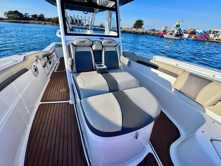 Suadha Yacht Photos Pics 2021 Tidewater 320 CC Adventure boat interior with cushioned seating on a sunny day.