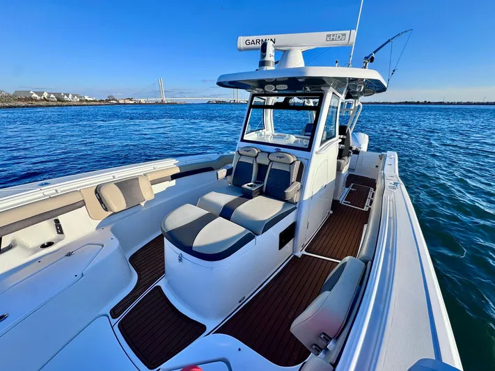 Suadha Yacht Photos Pics 2021 Tidewater 320 CC Adventure boat on calm blue water, featuring spacious seating and modern design.