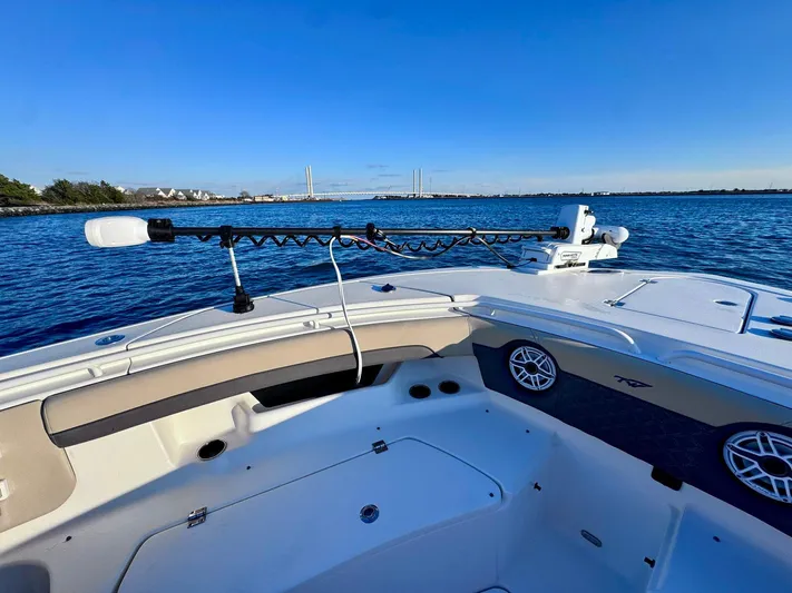 Suadha Yacht Photos Pics 2021 Tidewater 320 CC Adventure boat on calm water, featuring spacious deck and fishing equipment.