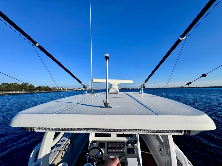 Suadha Yacht Photos Pics 2021 Tidewater 320 CC Adventure boat on calm water under clear blue sky.