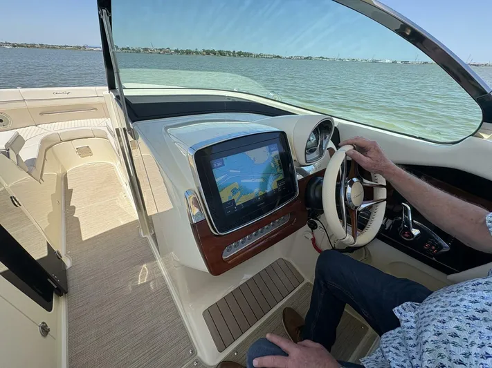  Yacht Photos Pics 2023 Chris-Craft Launch 31 GT dashboard with steering wheel and navigation screen on open water.