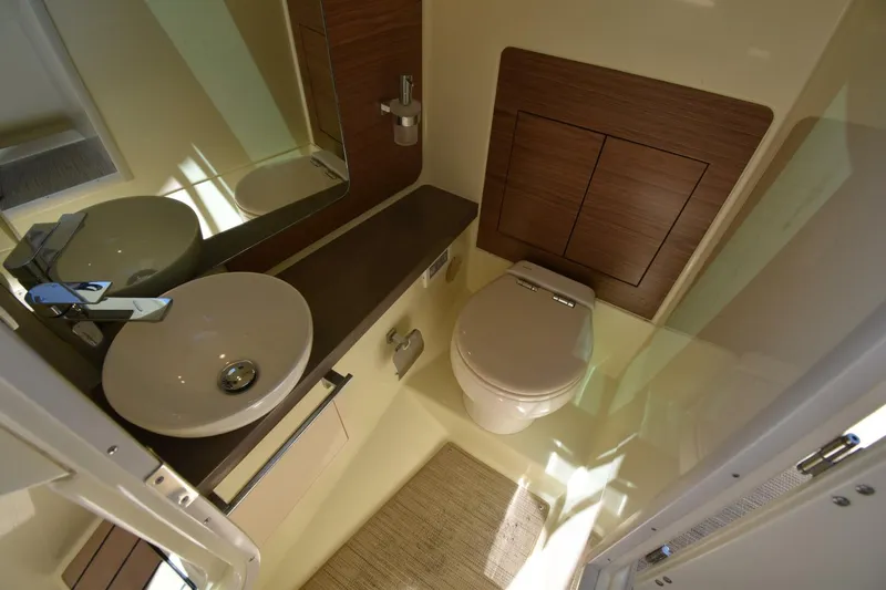 Yacht Photos Pics 2023 Chris-Craft Launch 31 GT bathroom interior with sink, toilet, and wooden accents.