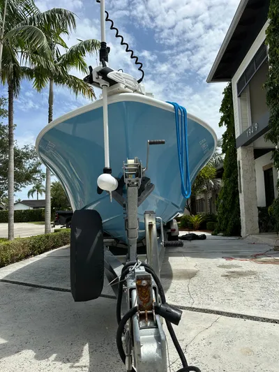  Yacht Photos Pics Blue Young 27 boat on trailer, parked outdoors near palm trees and building, 2019 model.