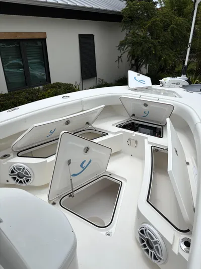  Yacht Photos Pics Open storage compartments on a 2019 Young 27 boat deck, featuring speakers and clean design.