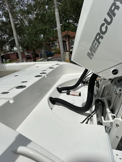  Yacht Photos Pics White Mercury outboard engine on a 2019 Young 27 boat, parked near trees.