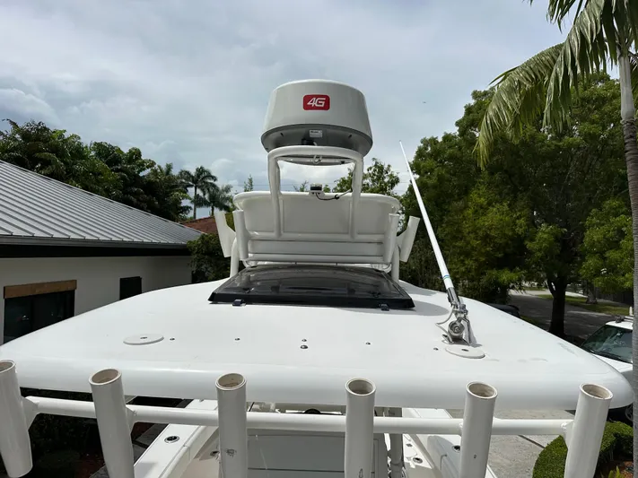  Yacht Photos Pics 2019 Young 27 boat with radar, antenna, and rod holders, surrounded by tropical trees.