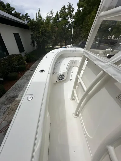  Yacht Photos Pics White 2019 Young 27 boat deck with seating and speaker, surrounded by greenery.