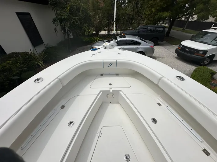  Yacht Photos Pics Bow view of a 2019 Young 27 boat, parked in a driveway.