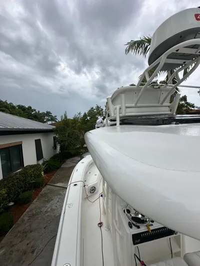  Yacht Photos Pics White Young 27 boat docked, cloudy sky, lush greenery, residential background, 2019 model.