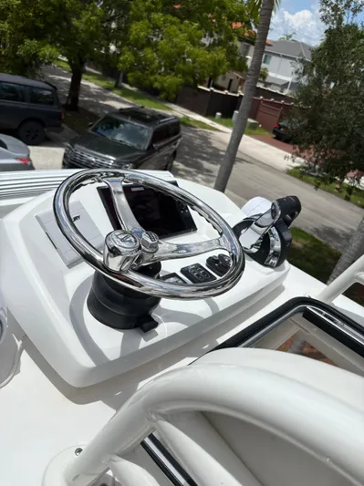  Yacht Photos Pics Steering wheel and controls of a 2019 Young 27 boat, parked in a residential area.