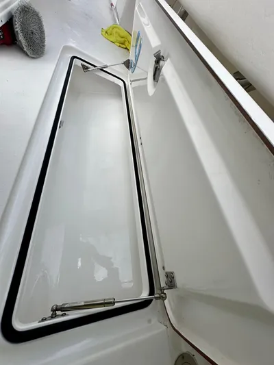  Yacht Photos Pics Open storage compartment on a 2019 Young 27 boat, with cleaning supplies nearby.