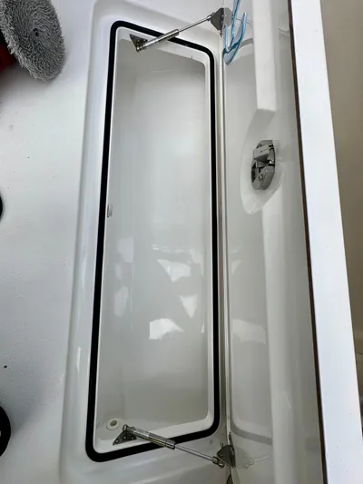  Yacht Photos Pics Open storage compartment on a 2019 Young 27 boat, featuring stainless steel hinges.