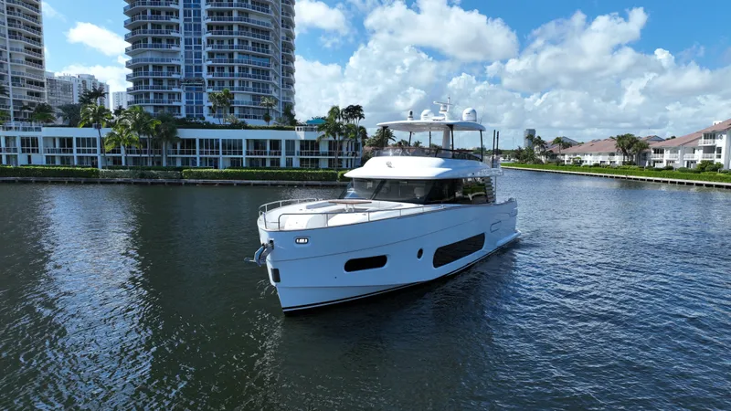 Triangle Of The Seas Yacht Photos Pics Azimut Magellano 66 yacht, 2022 model, cruising in a scenic waterfront setting.