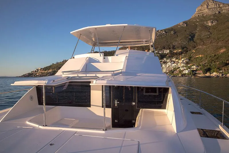 Dash Away Yacht Photos Pics 2015 Leopard 51 Powercat yacht on serene water with scenic mountain backdrop.