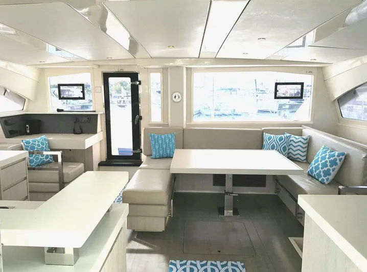 Dash Away Yacht Photos Pics Interior of 2015 Leopard 51 Powercat with modern seating and blue accent pillows.