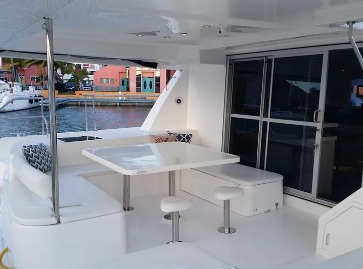 Dash Away Yacht Photos Pics Outdoor seating area on a 2015 Leopard 51 Powercat yacht, featuring a table and cushioned benches.