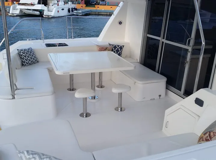 Dash Away Yacht Photos Pics 2015 Leopard 51 Powercat yacht deck with seating and table, docked at marina.