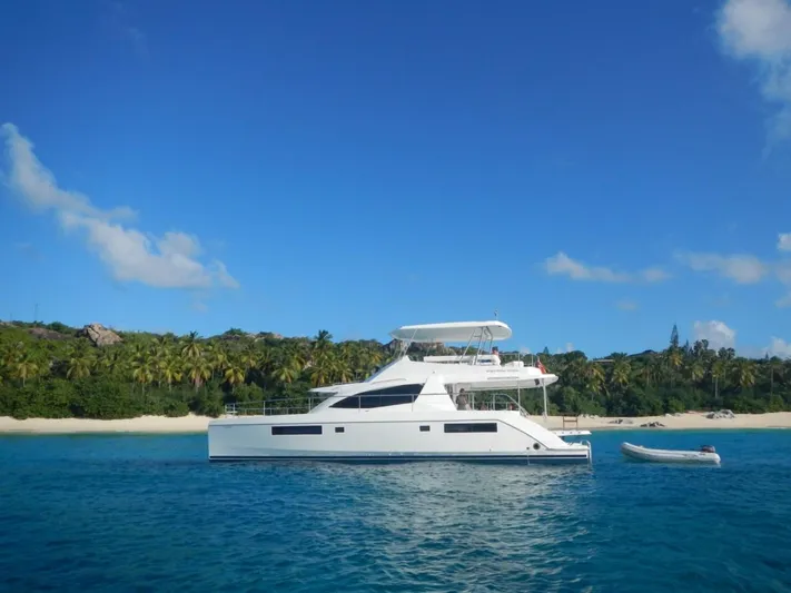 Dash Away Yacht Photos Pics 2015 Leopard 51 Powercat yacht anchored near tropical beach with clear blue sky.