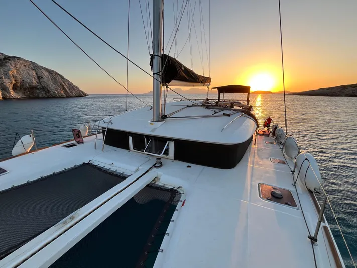 Myrto Yacht Photos Pics Lagoon 400 catamaran sailing at sunset, 2012 model, with scenic ocean view.