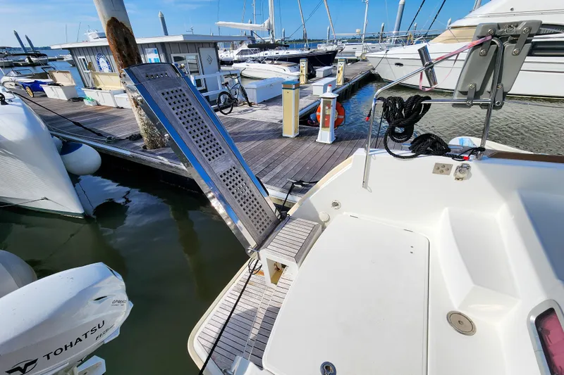 Myrto Yacht Photos Pics Lagoon 400 catamaran docked at marina, featuring a boarding ramp and Tohatsu outboard motor.