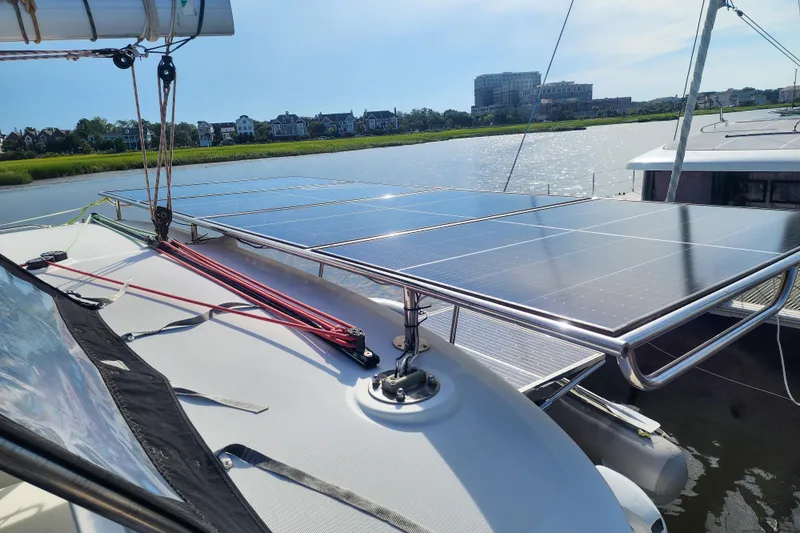 Myrto Yacht Photos Pics 2012 Lagoon 400 catamaran with solar panels on deck, docked by a scenic waterfront.