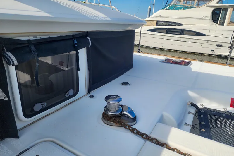 Myrto Yacht Photos Pics 2012 Lagoon 400 yacht deck with winch and chain, docked beside another boat.