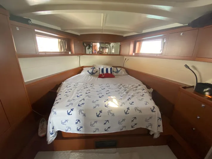  Yacht Photos Pics Luxurious cabin interior of 2014 Beneteau Oceanis 48 yacht with nautical-themed bedding.