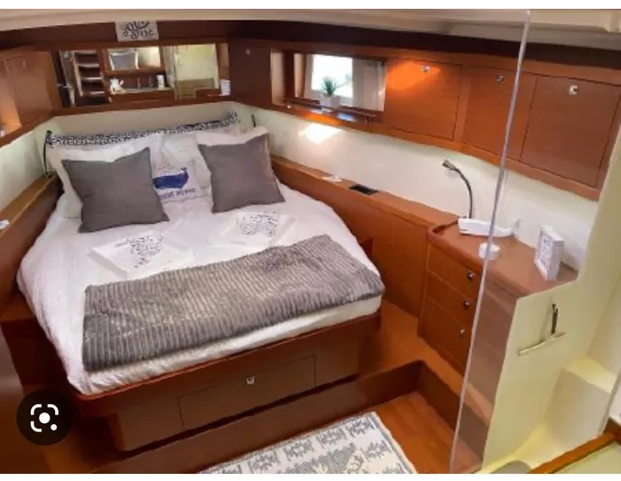  Yacht Photos Pics Luxurious cabin interior of 2014 Beneteau Oceanis 48 yacht with cozy bed and wooden furnishings.