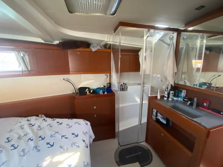  Yacht Photos Pics Interior of 2014 Beneteau Oceanis 48 yacht with wooden cabinetry and compact bathroom.